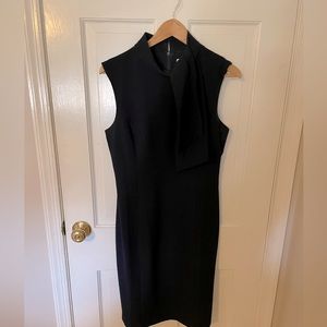 Sleeveless dress with off center faux tie bow at neck